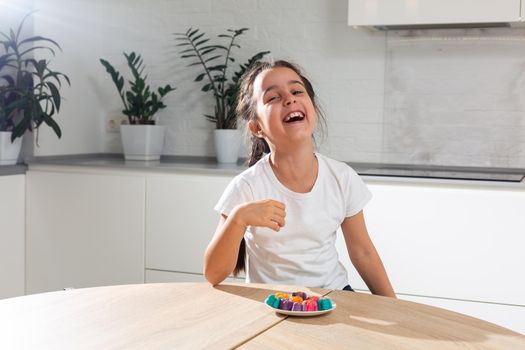 Hand of little girl decorating homemade candy.