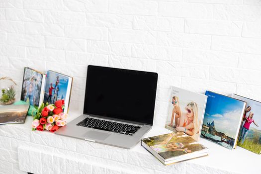 photo book and flowers tulips as a holiday gift lie on the shelf.