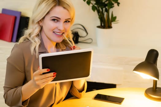 Portrait of a happy casual businesswoman sitting at her workplace in office