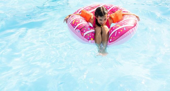 Swimming - little girl playing in blue water - space for text