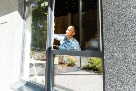 Male worker installing window in flat, closeup.