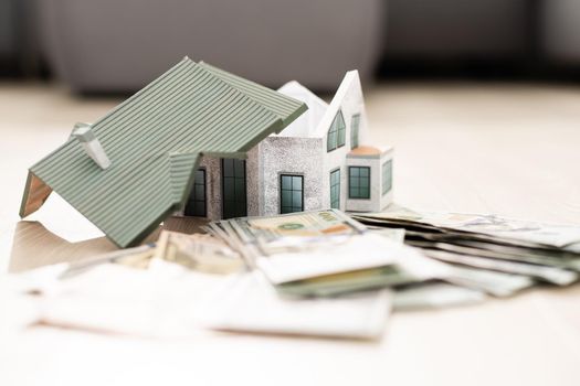 The model of the house costs on a pile of notes. Purchase and sale.