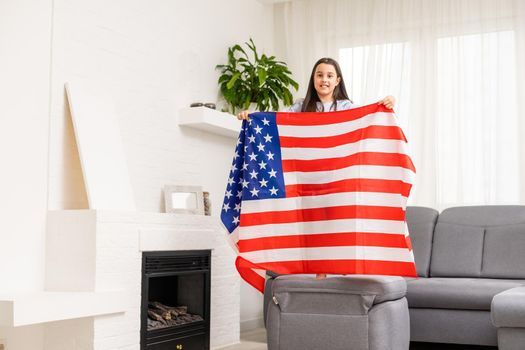 Portrait of a little girl with the flag of America. American education, study in America.