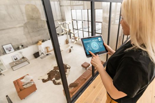 Female hands hold a tablet computer with system clever house on a screen.