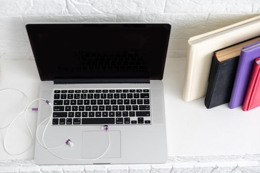 Working desk. Open laptop, books and other office supply