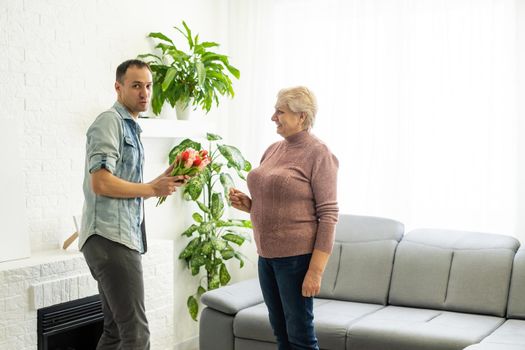 Son giving mother flowers tulips.