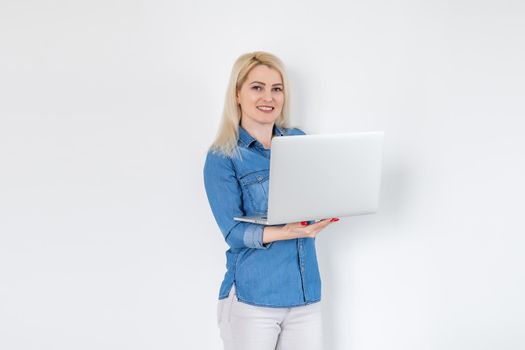 Concentrated at work. Confident young woman in smart casual wear working on laptop while sitting near window in creative office or cafe.