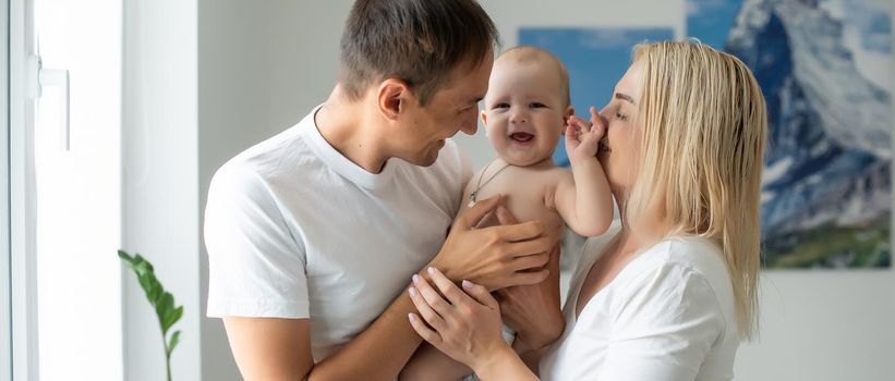 A Happy young family with baby in white bedroom.