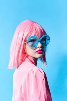 pretty woman in blue glasses wears a pink wig studio model unaltered. High quality photo
