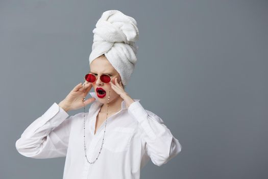 fashionable woman red sunglasses cosmetics with towel on head Gray background. High quality photo