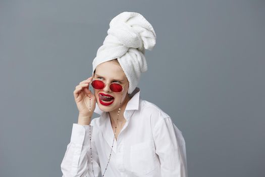 fashionable woman with a towel on his head in a white shirt Gray background. High quality photo