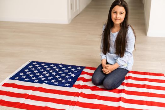Portrait of a little girl with the flag of America. American education, study in America.