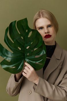 portrait of a woman in coat red lips fashion palm leaf Lifestyle posing. High quality photo