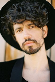 Portrait of a young man in a black hat and jacket. High quality photo