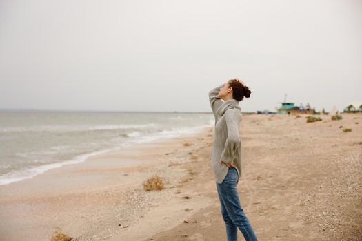 portrait of a woman cloudy weather by the sea travel fresh air Happy female relaxing. High quality photo