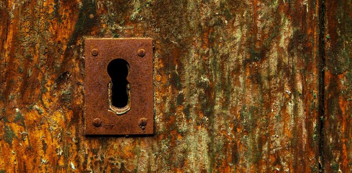 keyhole in an old door with an interesting texture, a remnant of an old entrance security, vintage