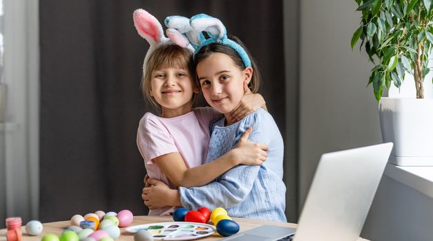 two little girls with ears hold eggs - Easter symbols. Easter egg