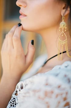 Young woman touches her chin with her fingers. Close-up. High quality photo