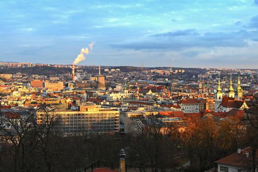 Steaming chimneys with houses in the city. Concept for environment and industry. Background with city landscape at sunset. Brno - Czech Republic - Europe.