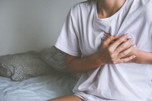 Woman holding chest because of heart disease, heart attack, heart pain or chest pain. High quality photo