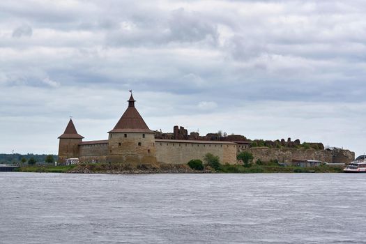 Natural landscape with a view of the old fortress by the lake. Sunny spring day