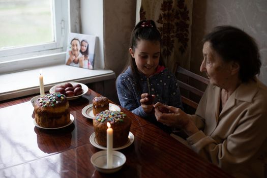 senior woman with easter eggs and Easter cake.