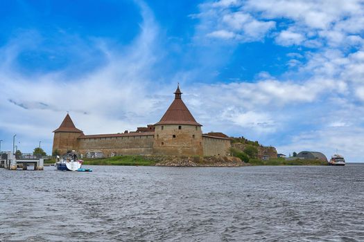 Natural landscape with a view of the old fortress by the lake. Sunny spring day