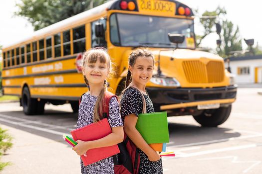 Lucky to meet each other. Cheerful smart schoolgirls. Happy schoolgirls outdoors. Small schoolgirls wear school uniform. Cute schoolgirls looking charming. Ending of school year