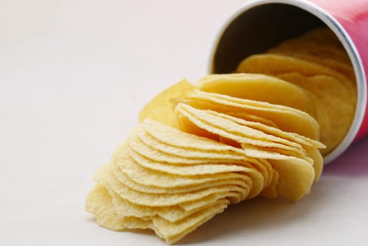 Bowl with tasty potato chips on wooden background