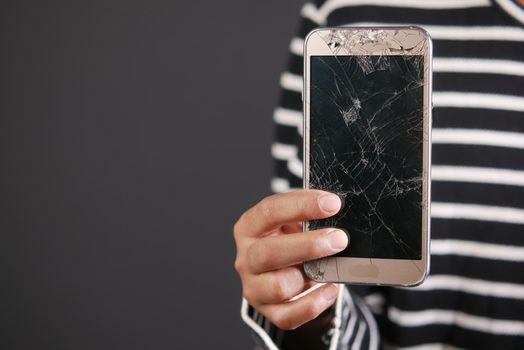 Close up of man hand holding broken smart phone