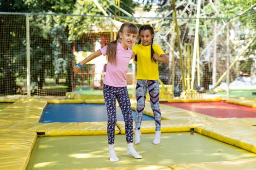 Happy children jumping on trampoline.