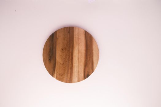 wooden chopping board on color background top down .