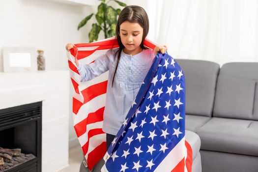 Portrait of a little girl with the flag of America. American education, study in America.