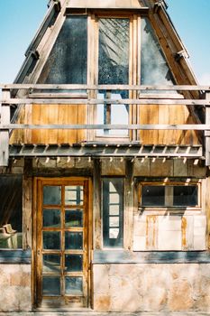 Triangular wooden house with a balcony and a glazed door. Close-up. High quality photo