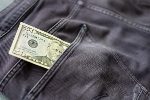 American dollar bills in jeans pocket background.