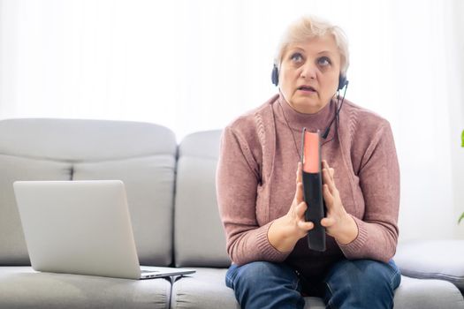 Woman with bible and laptop in front of her connected to online church services durring the covid 19 outbreak