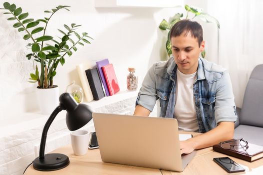 Man Using Laptop On Desk At Home