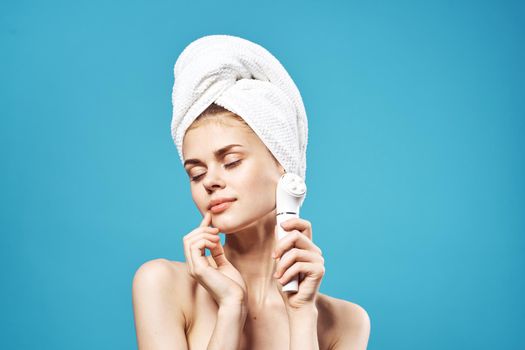 cheerful woman with bare shoulders with a massager in her hands cosmetology dermatology. High quality photo