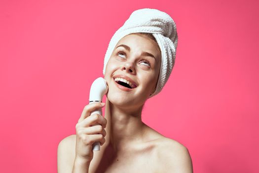 woman with towel on head cleaning skin naked shoulders pink background. High quality photo
