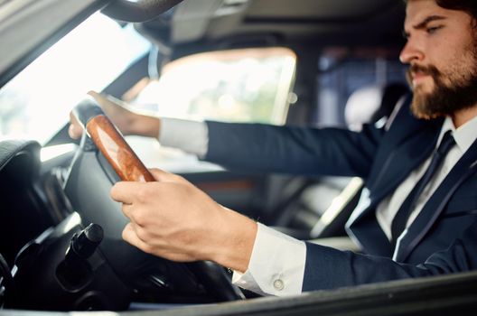 bearded man in a suit in a car a trip to work success service rich. High quality photo