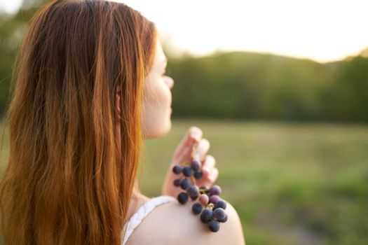 woman with bunch of grapes outdoors leisure walk fresh air. High quality photo