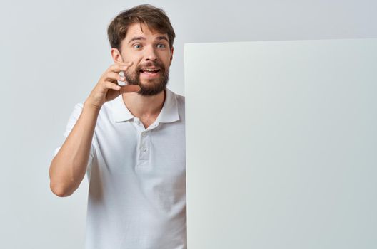 Cheerful man in a white t-shirt mocap poster discount advertising White background. High quality photo