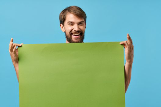 Cheerful man green paper in the hands of marketing isolated background. High quality photo