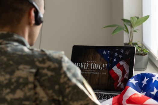 Soldier working with laptop in headquarters building.