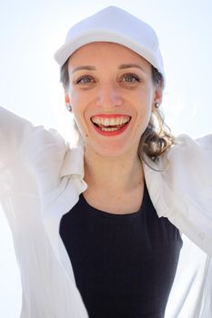 Close up female portrait of young active girl in black top, white shirt, basketball cap outdoors, happy people concept.
