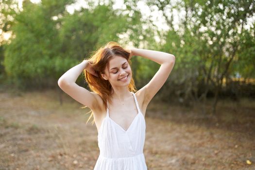 cheerful woman gesturing with her hands freedom nature sun. High quality photo