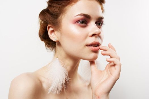 woman with bare shoulders in fluffy earrings jewelry Glamor bright makeup. High quality photo