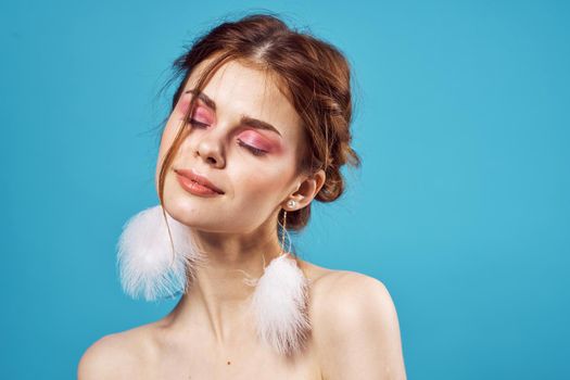 woman with bright makeup fluffy earrings posing close-up. High quality photo
