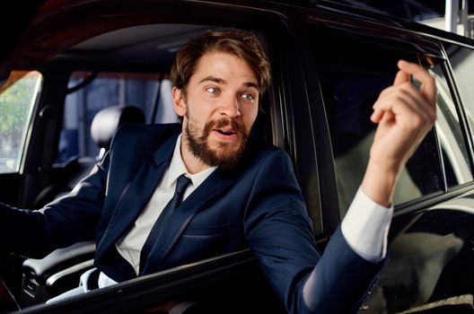 bearded man in a suit in a car a trip to work service. High quality photo