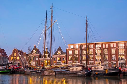 Decorated traditional sailing ship in the harbor from Harlingen in the Netherlands at sunset